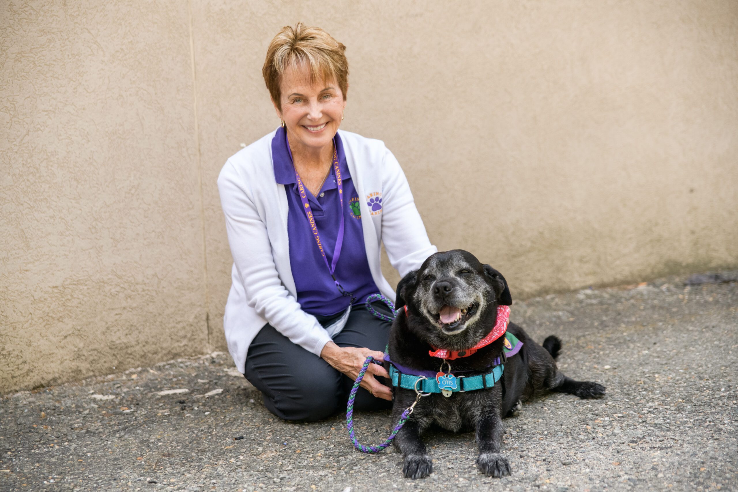 An adult and a dog sit in an alley