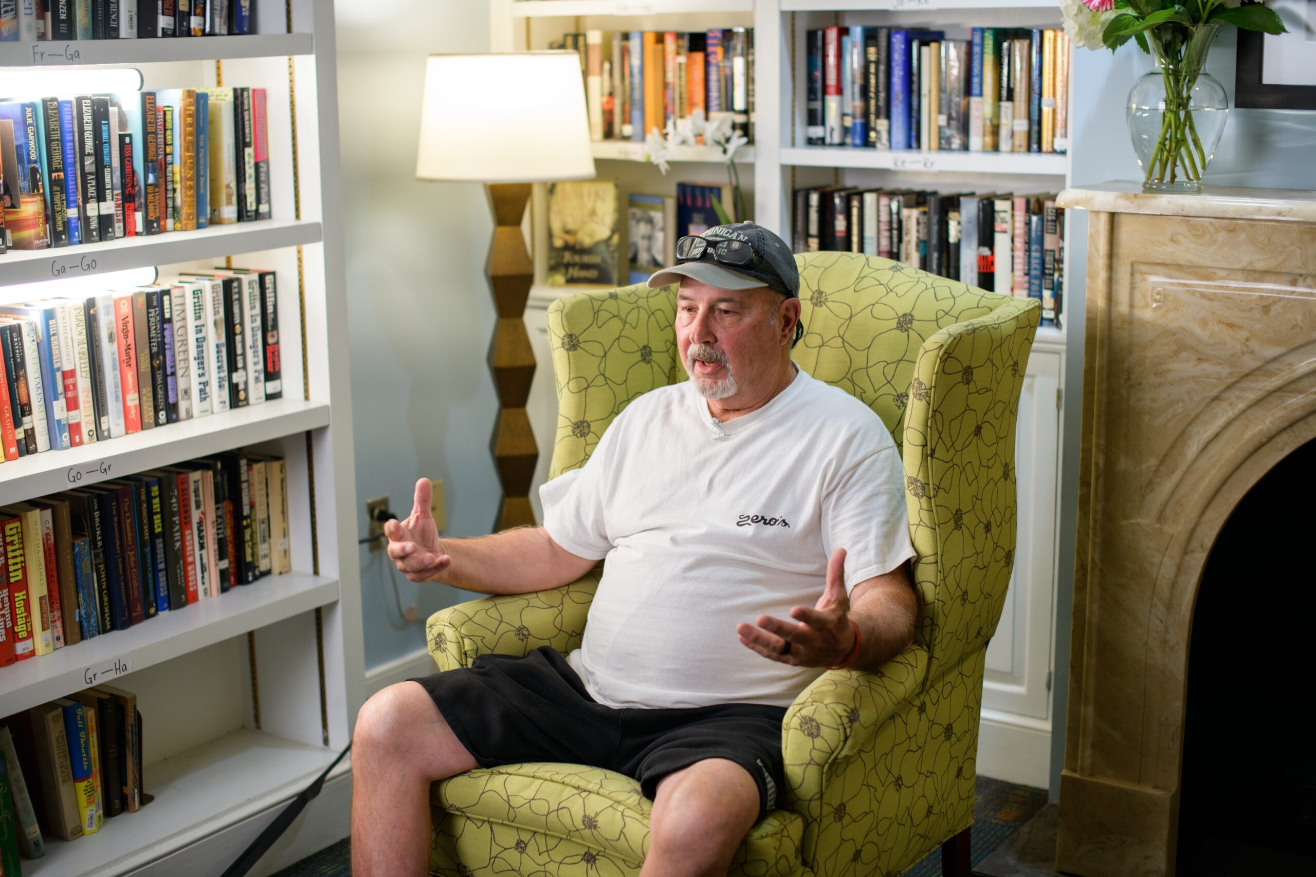 an adult sits in a chair in a library