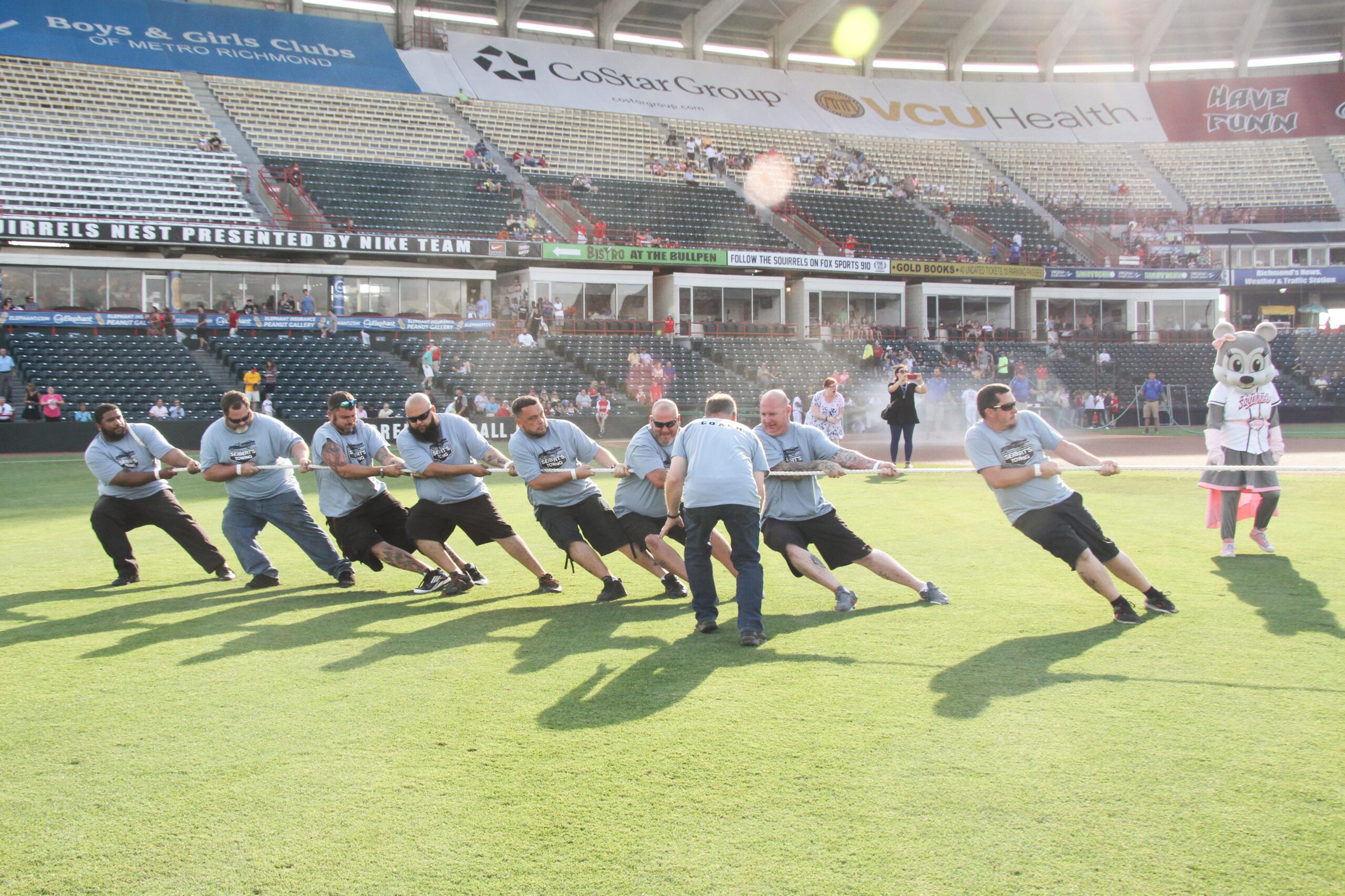 several adults strain on a rope during a game of tug of war