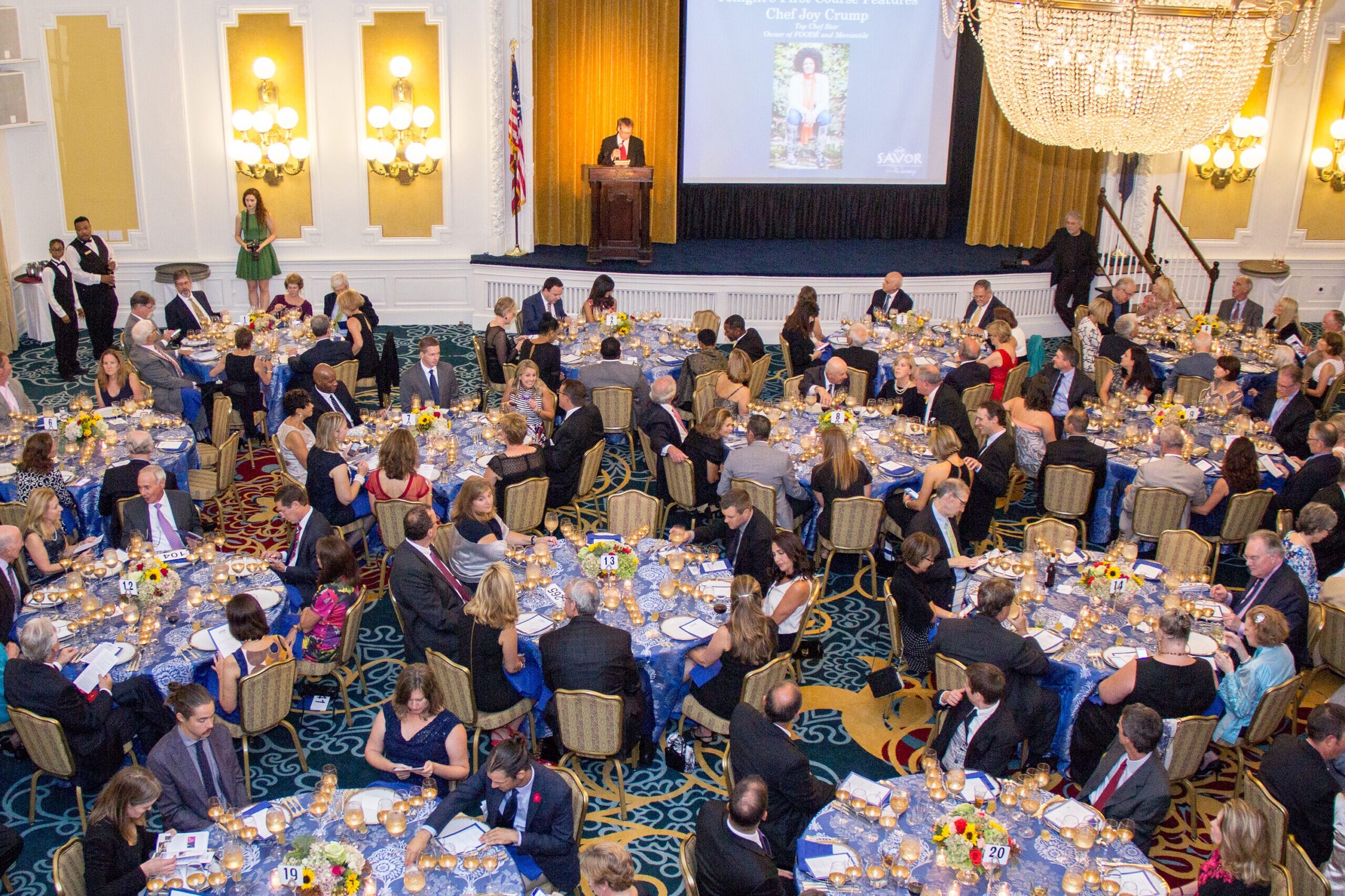 A seated dinner with several tables and many people