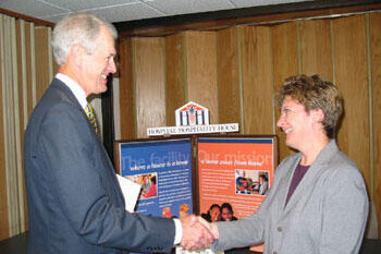 Paul Timmreck, VCU senior vice president for finance and administration and chair of the combined campaign, greets Ellen Sandridge, with the Hospital Hospitality House, during CVC kickoff at the VCU Medical Center. HHH and four other charities set up information booths. Photo by Michael Ford, University News Services