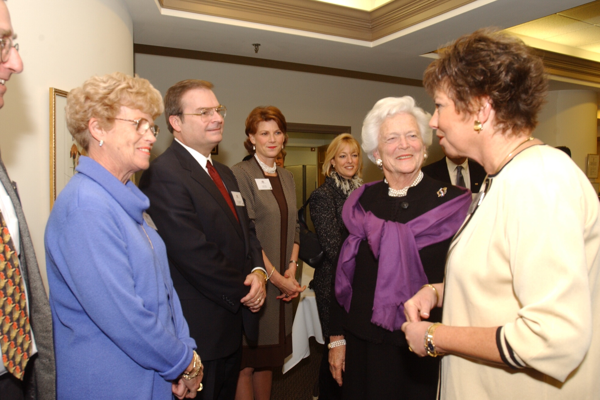 A group of smiling people stand withBarbara Bush at The Doorways