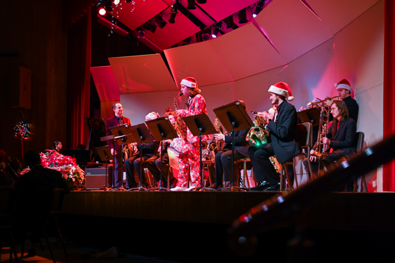 Individuals wearing festive outfits play instruments