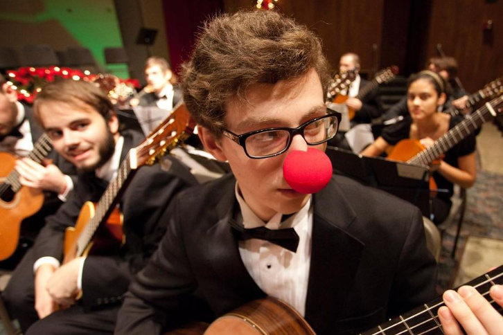 Musicians play guitar while wearing festive finery