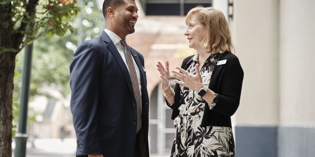 Two smiling adults chat outside The Doorways