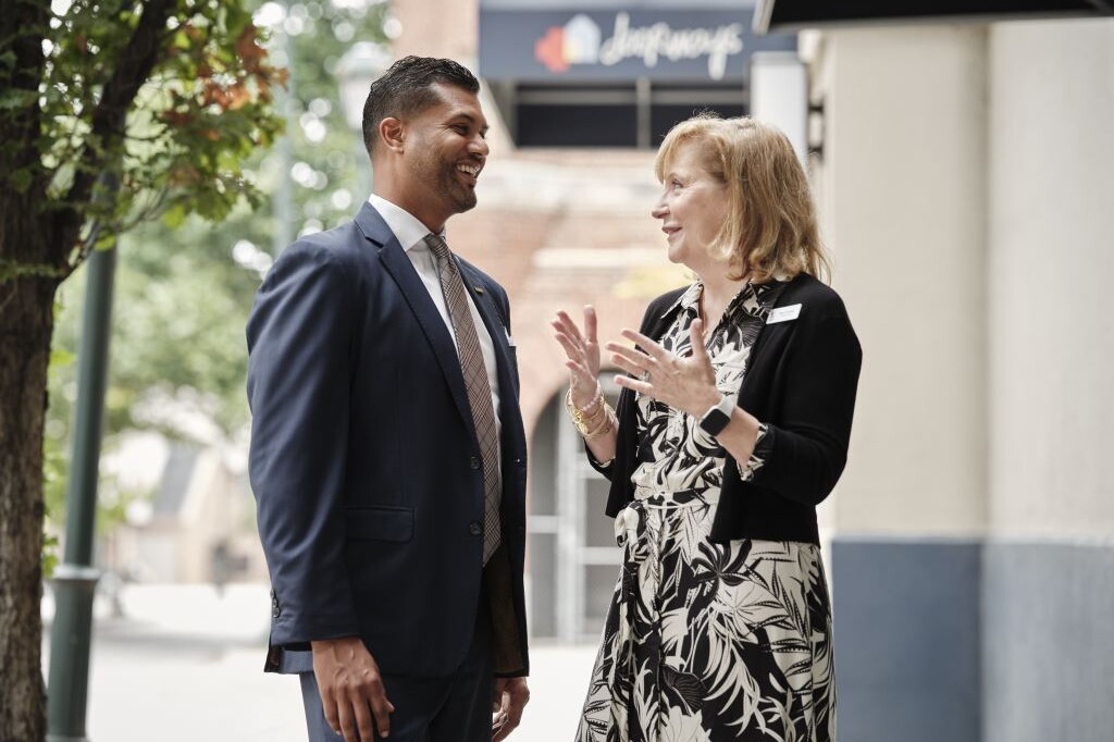 Two smiling adults chat outside The Doorways