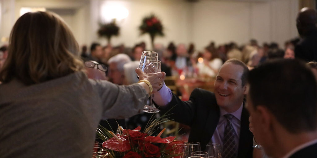 Two smiling adults cheers at SAVOR 2024