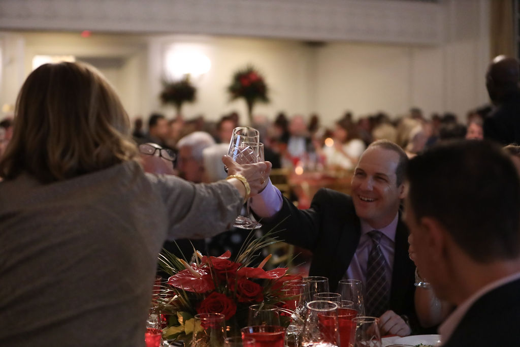 Two smiling adults cheers at SAVOR 2024