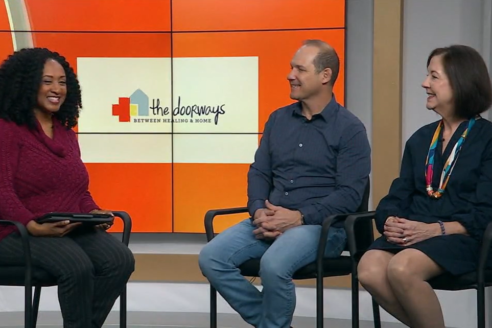 Three smiling adults sit in the W-R-I-C studio