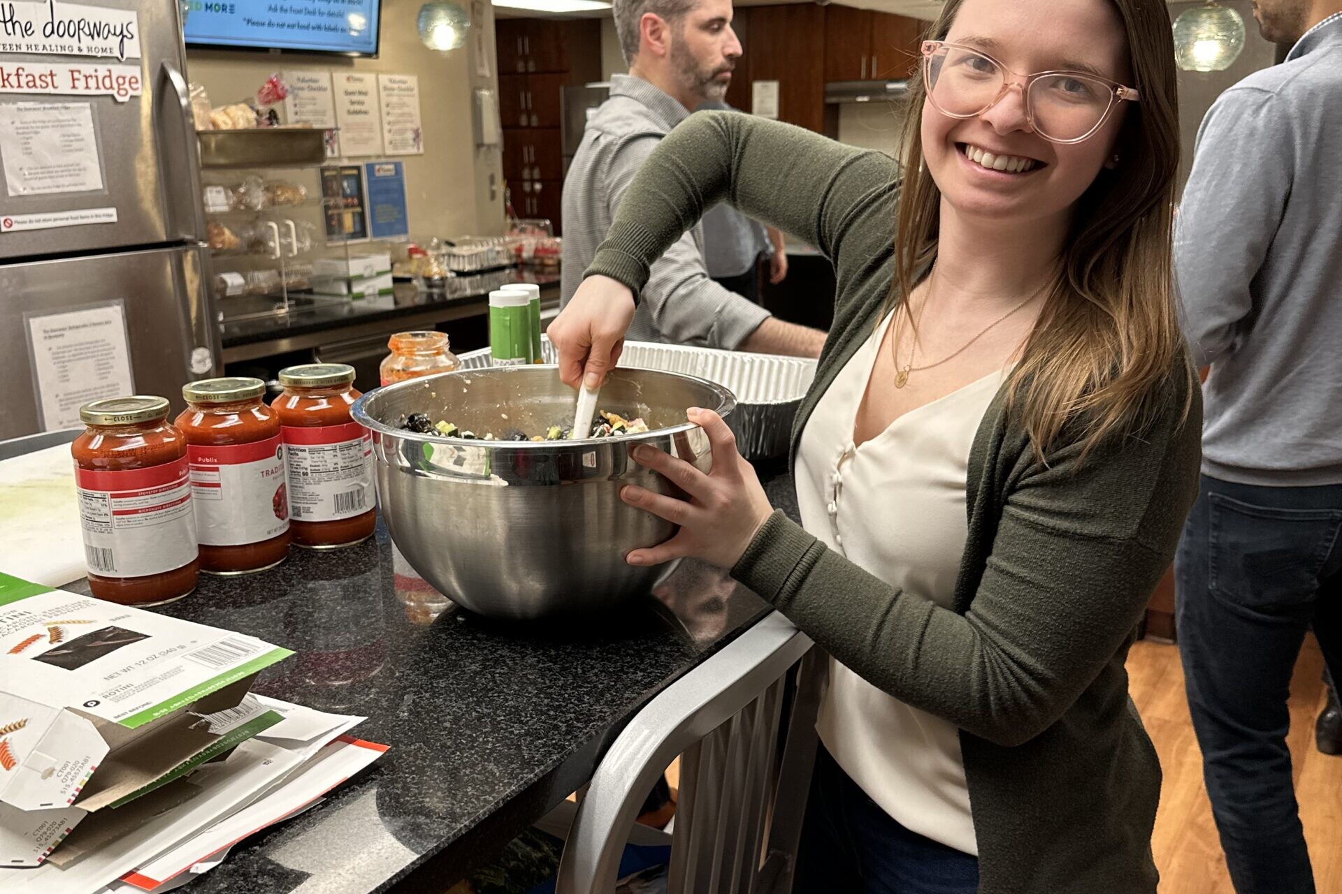 Photo of a smiling adult mixing a salad