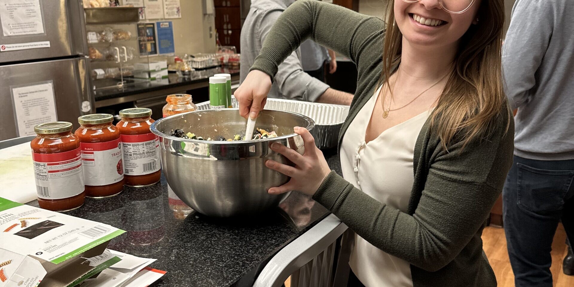 Photo of a smiling adult mixing a salad