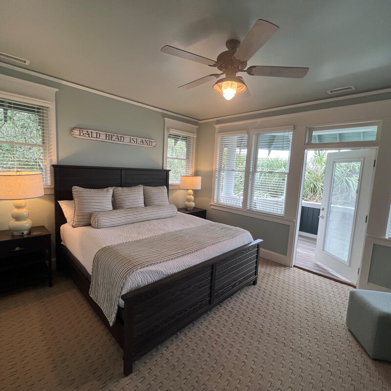 An elegant bedroom with a beach view out the window